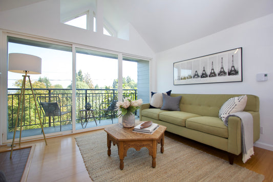 Furnished living room with sofa, armchair, table and a wide view through the windows.