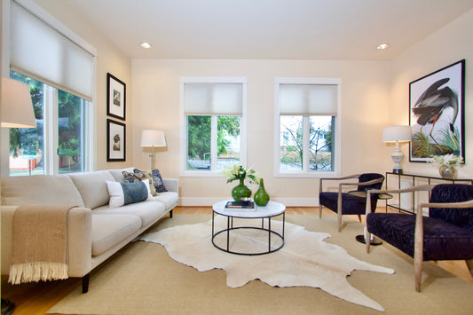 Living room with an upholstered sofa, lounge chairs and a patterned rug.